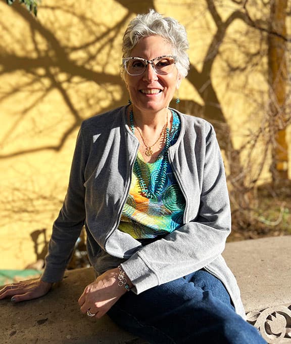 Robin Spindt smiling in her colorful creative workspace